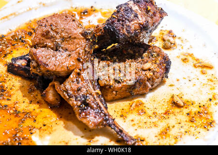 Well done Rib eye steak in greasy white plate. The steak with tender cooking is well done and is glistening with the juices drying on the white plate. Stock Photo