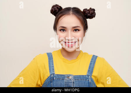 Portrait of young Asian woman wearing  jeans dungaree on white background Stock Photo