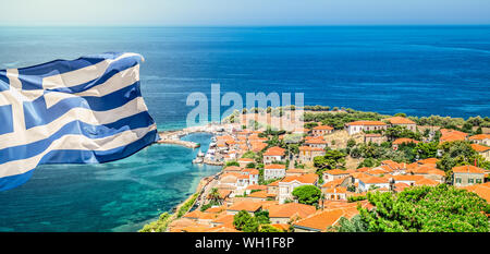 Greece National Flag on top of the castle of Molyvos. Aerial view of Mithymna town. Stock Photo