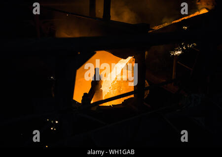 Foundry - molten metal poured from ladle into mould - lost wax casting. Stock Photo