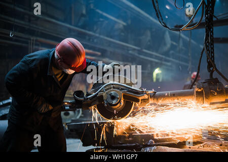 Welder used grinding stone on steel in factory with sparks. Stock Photo