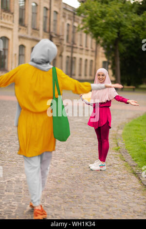 Two muslim students feeling happy while meeting near university Stock Photo