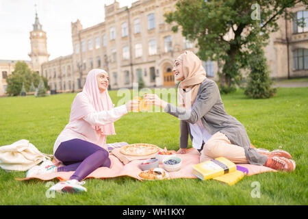 Muslim students having nice lunch break outside near university Stock Photo