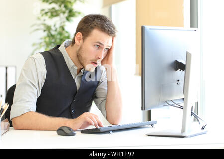 Worried executive complaining after discover mistake on computer at office Stock Photo