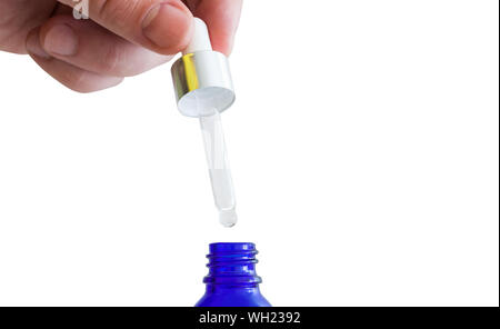 Cropped Image Of Hand Holding Pipette On Bottle Over White Background