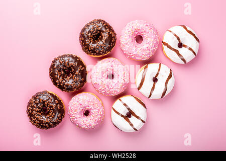 Colorful donuts on rose background Stock Photo