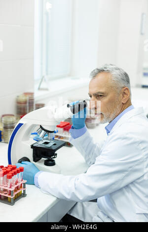 Serious grey-haired man being deep in thoughts Stock Photo