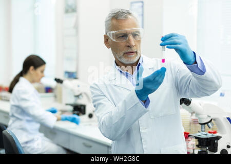 Serious mature researcher working in modern laboratory Stock Photo