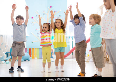 Group of preschool children doing kids gymnastics in gym Stock Photo