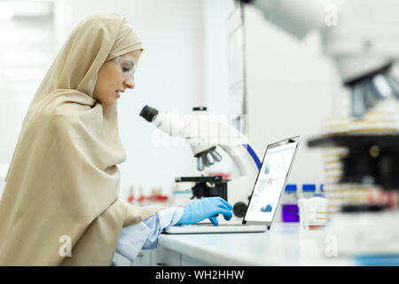 Delighted young international researcher working in laboratory Stock Photo