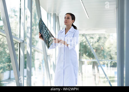 Cheerful brunette female being deep in thoughts Stock Photo
