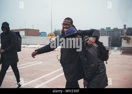 three young african men outdoor together in the street hugging having fun – relationship, interaction, cheerful Stock Photo