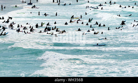 Holidaymakers enjoying themselves in the sea seen in silhouette at Fistral in Newquay in Cornwall. Stock Photo