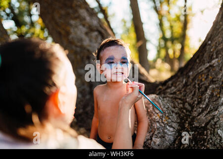 Kid painting himself of dracula to halloween on the forest Stock Photo