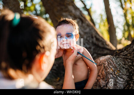 Kid painting himself of dracula to halloween on the forest Stock Photo