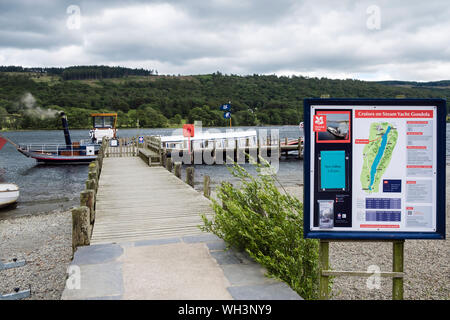 Sign for Coniston Launch steam yacht Gondola moored at jetty on Coniston Water in Lake District National Park. Cumbria, England, UK, Britain Stock Photo