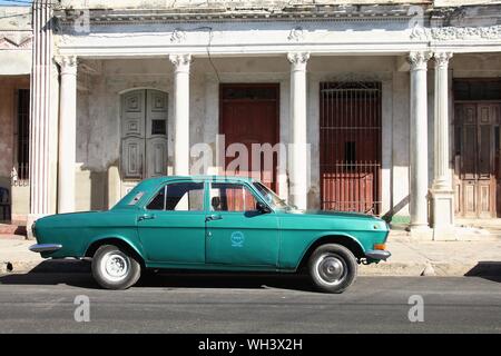 CIENFUEGOS, CUBA - FEBRUARY 3, 2011: Classic old Soviet Volga car in the street in Cienfuegos. Cuba has one of the lowest car-per-capita rates (38 per Stock Photo