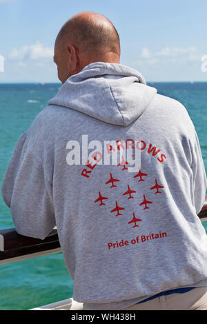 Man wearing hoodie with Red Arrows Pride of Britain on the back at Bournemouth Air Festival, Dorset UK in August Stock Photo