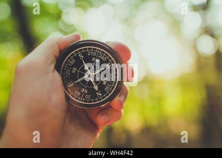Compass in a Hand of Hiker. Useful Equipment on a Trailhead. Stock Photo