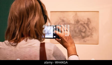 Visitor taking a photo of one of Leonardo Da Vinci's amazing drawings in London which marks the 500th anniversary of the death of Leonardo da Vinci. Stock Photo