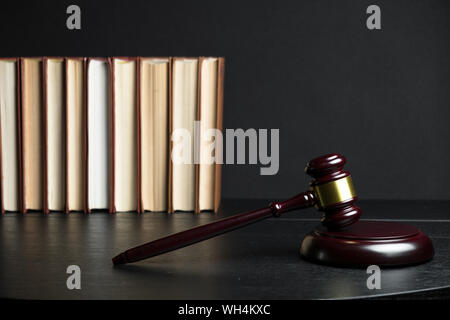 Judge gavel beside pile of books on black wooden background Stock Photo ...