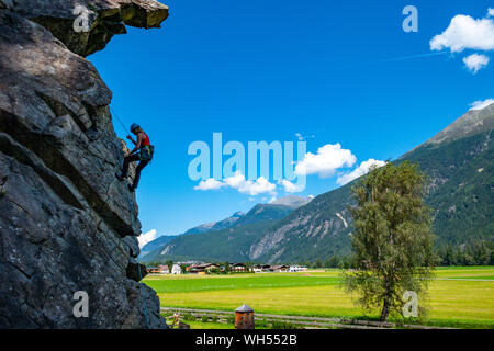 Female rock climber hanging on rope on cliff in OtztalValley, Tirol, Austria Stock Photo