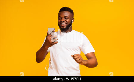 Happy african man listening music with earphones and mobile phone Stock Photo