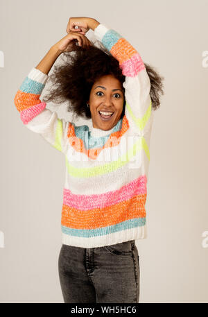 Portrait of happy young african american female laughing and having fun in multicolor striped jumper isolated over neutral background. People, human p Stock Photo
