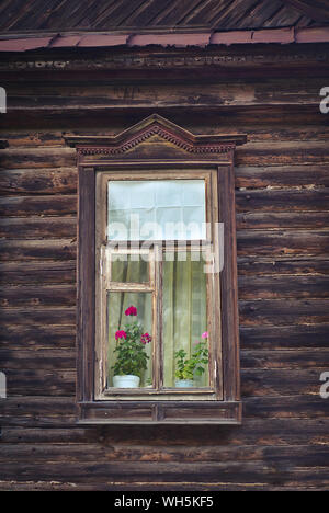 Window with flower in an old wooden house in Russia Stock Photo