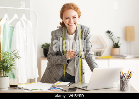 Happy designer woman work on computer in tailor workshop Stock Photo