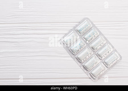 Chewing gums on white wooden background. Stock Photo