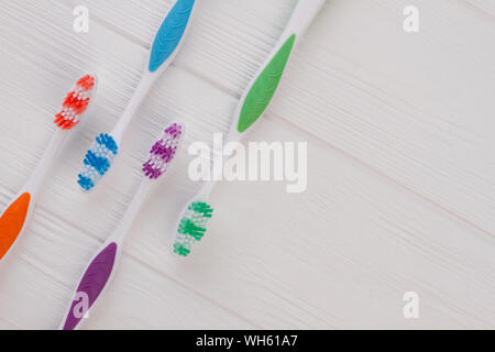 Group of four soft toothbrushes on wooden background. Stock Photo