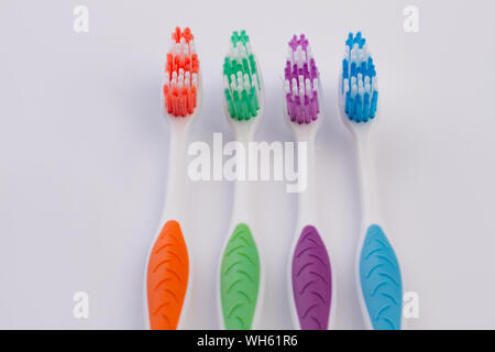 Four colored toothbrushes on white background. Stock Photo