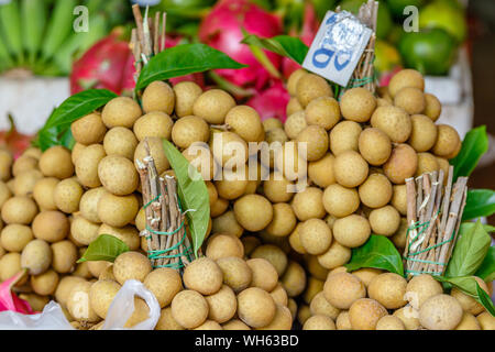 Bunches of Thai longan fruit on the market. Bangkok, Thailand. Stock Photo