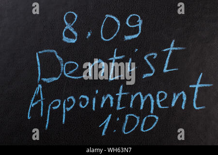 Dentist appointment reminder on chalkboard. Stock Photo