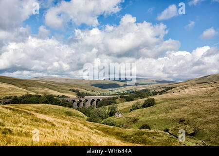 Freight train passing over the Dent Head viaduct on the famous Settle to Carlisle rail-line in the scenic Yorkshire Dales Stock Photo