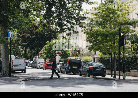 London, UK - July 18, 2019: Parking warden crossing the road in Marylebone, a chic residential area of London famous for Baker Street and Madame Tussa Stock Photo