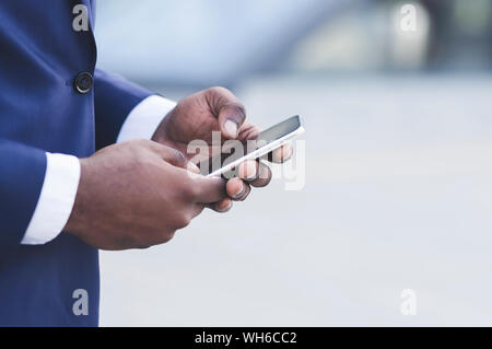 Afro Businessman Hands Using Smartphone In City, Closeup Stock Photo