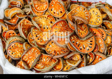 Sliced and sun-dried Aegle marmelos or bael fruit in a bag at a street market in Bangkok Chinatown. Thailand. Stock Photo