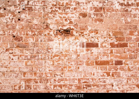 Old orange brick wall with cracks on the bricks. shabby vintage wall. Stock Photo