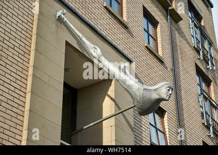 The Attendant head sculpture hanging over the doorways to modern tenement blocks in New Gorbals, Glasgow, UK Stock Photo