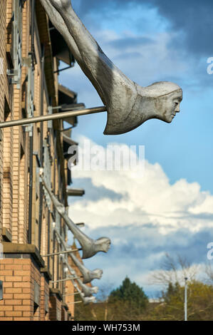 The Attendant head sculpture hanging over the doorways to modern tenement blocks in New Gorbals, Glasgow, UK Stock Photo