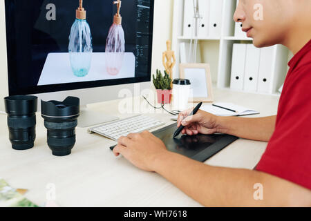 Cropped image of retoucher using graphic tablet when working with photo of soap glass dispensers Stock Photo
