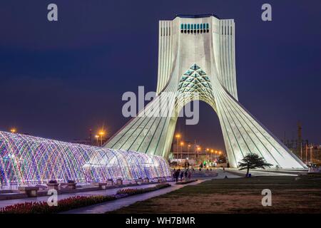 Illuminated Azadi Tower at dusk, Tehran, Iran Stock Photo