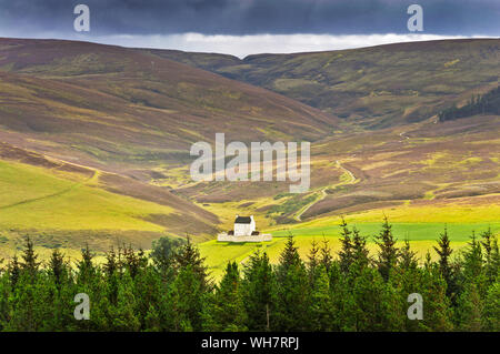 CORGARFF CASTLE ABERDEENSHIRE SCOTLAND THE WHITE STRONGHOLD VIEWED FROM THE LECHT ROAD WITH PURPLE HEATHER ON THE HILLS IN LATE SUMMER Stock Photo