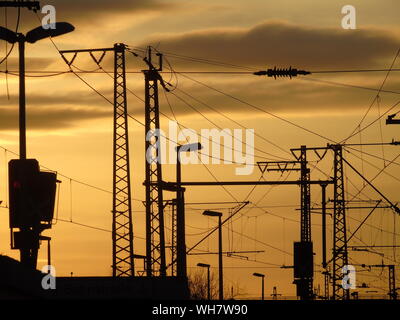 A view of power line pylons and railway with train crossing marshes ...