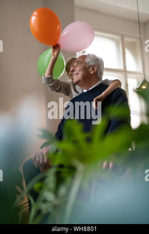 Happy grandfather and grandson playing with balloons at home Stock Photo