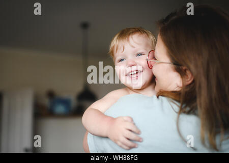 Portrait of little boy on his mother's arms at home Stock Photo
