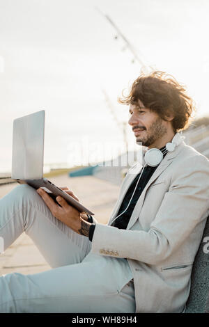 Businessman working on laptop outdoors Stock Photo
