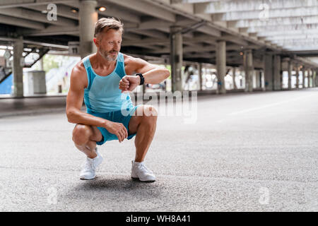 Sporty man checking his smartwatch Stock Photo